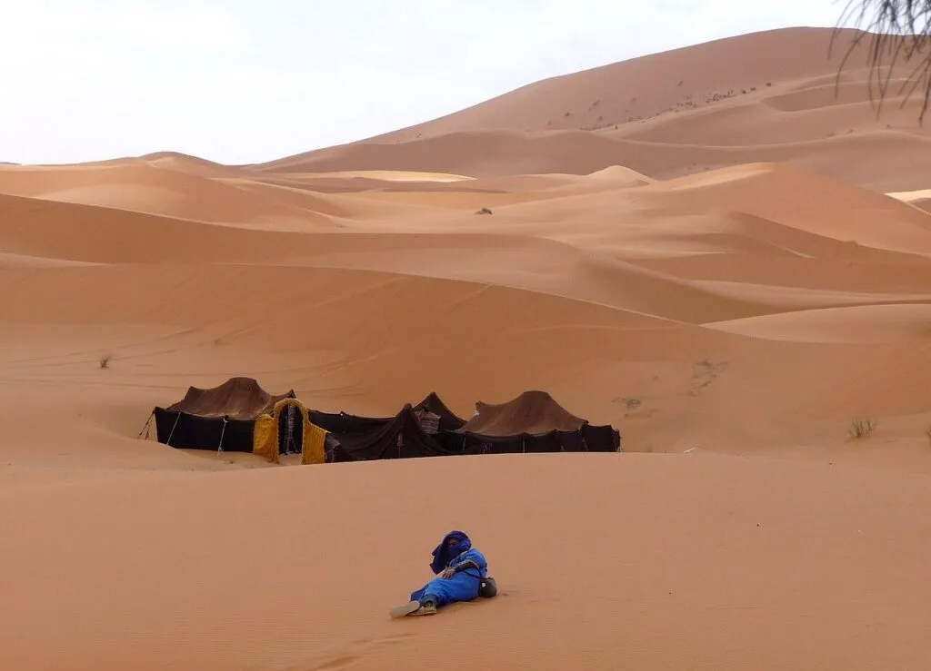 What to pack for a morocco desert tour — Packed backpack and scarf ready for a Morocco desert tour